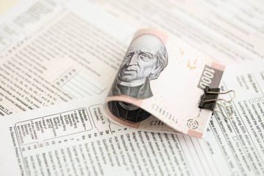 Meksika Pezosu 'nun büyük meblağlı para faturaları masada duruyor. Vergi formları da yakında. Muhasebe ve vergilendirme kavramı