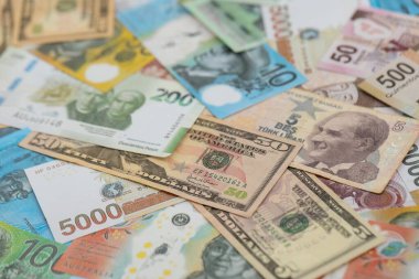 Farklı para birimlerinden ve ülkelerden yüklü miktarda para. Uluslararası nakitin çeşitli arka planında büyük bir yığın var.