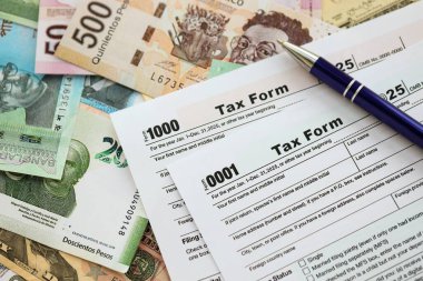 Değişik para birimlerinden ve ülkelerden oluşan büyük miktarlarda para ve vergi beyannamesi doldurulmaya hazır. Uluslararası nakitin çeşitli arka planında büyük bir yığın var.