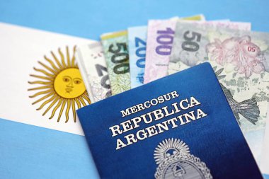 Arjantin pezosu büyük miktarda para ve pasaport Arjantin bayrağına yakın duruyor. Finans ve bankacılık kavramı