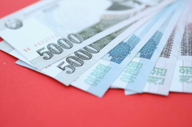 Kuzey Kore büyük miktarlarda para kazandı. Yakın plan kırmızı masada yatıyor. Finans ve bankacılık kavramı