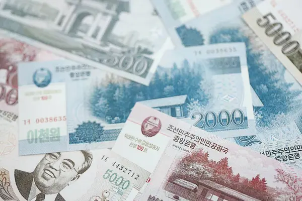 Kuzey Kore büyük miktarlarda para kazandı. Beyaz renkli masada yatıyor. Yakın plan. Finans ve bankacılık kavramı