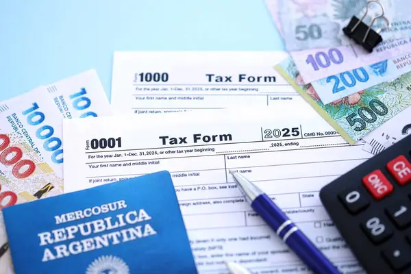 Arjantin Pezosu 'nun para faturaları kalem, hesap makinesi, pasaport ve vergi formlarıyla dolu. Finans ve bankacılık kavramı