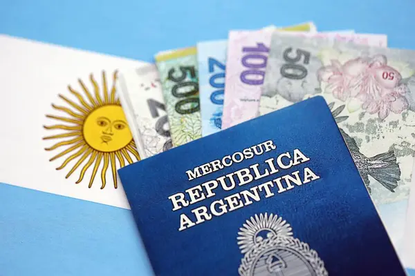 Arjantin pezosu büyük miktarda para ve pasaport Arjantin bayrağına yakın duruyor. Finans ve bankacılık kavramı