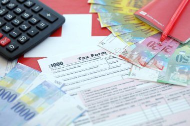 İsviçre frangı banknotları ve vergi formları. Mevcut para faturaları vergi formu ve bayraklarda yatıyor. İsviçre 'de vergilendirme kavramı