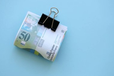 Mavi arka planda İsviçre frangı banknotları. Mevcut frank para faturaları büyük miktarda masada yatıyor. İsviçre 'de iş ve yatırım kavramı