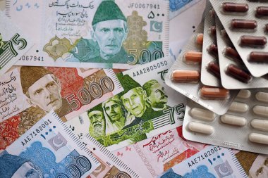 Pakistan banknotları ve ilaç hapları. Pakistan 'ın mevcut para ve uyuşturucu faturaları büyük miktarda masada yatıyor. Pakistan 'da ilaç ve eczane kavramı