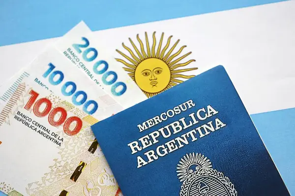 Arjantin pezosu büyük miktarda para ve pasaport Arjantin bayrağına yakın duruyor. Finans ve bankacılık kavramı