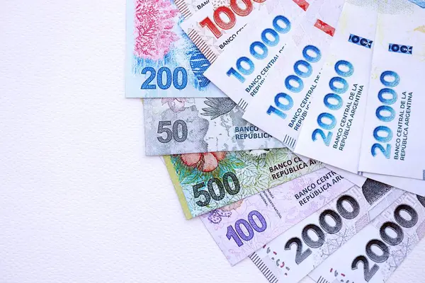 Arjantin pezosu büyük miktarlarda para beyaz masada yakın planda yatıyor. Finans ve bankacılık kavramı