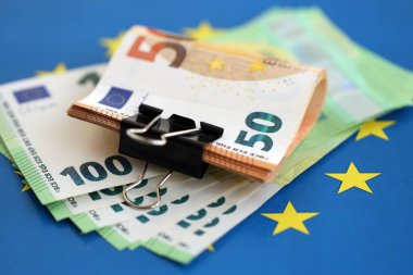 Avrupa sendikasının mavi bayrağına bir deste avroluk banknot yakın. Avrupa 'da iş ve ekonomi kavramı