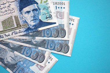 Pakistan banknotları mavi arka planda. Pakistan 'ın mevcut para faturaları büyük miktarda masada yatıyor. Pakistan 'da iş ve yatırım kavramı
