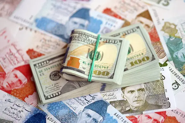 Amerikan dolarları yığını Pakistan Rupi banknotlarının büyük bir miktarına yakın duruyor. Amerikan para demeti Pakistan 'ın para banknotlarında yatıyor. Pakistan 'da ekonomi ve döviz kuru kavramı