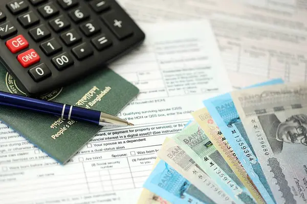 Bangladeşli para banknotları kalem, hesap makinesi, pasaport ve vergi formlarıyla dolu. Finans ve bankacılık kavramı