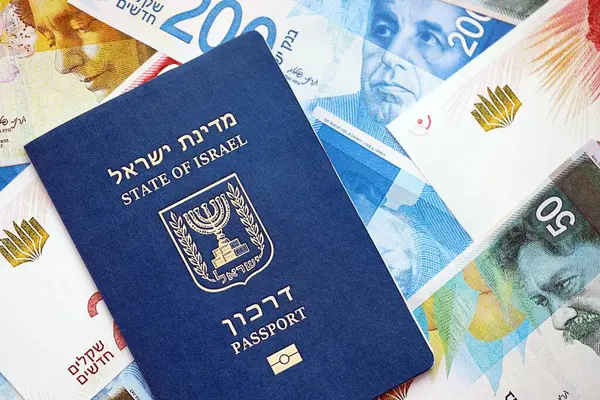 Israel New Shekels banknotları ve pasaportu. İsrail 'in mevcut para faturaları ve biyometrik geçiş kartı büyük miktarda masada yatıyor. İsrail 'de seyahat ve tatil kavramı