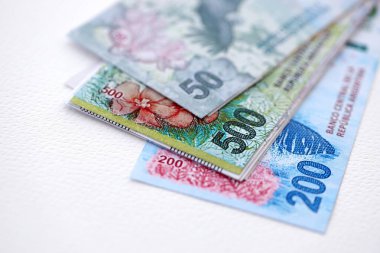 Arjantin pezosu büyük miktarlarda para beyaz masada yakın planda yatıyor. Finans ve bankacılık kavramı