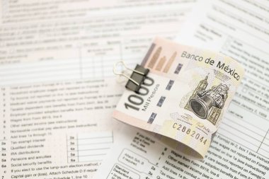 Meksika Pezosu 'nun büyük meblağlı para faturaları masada duruyor. Vergi formları da yakında. Muhasebe ve vergilendirme kavramı