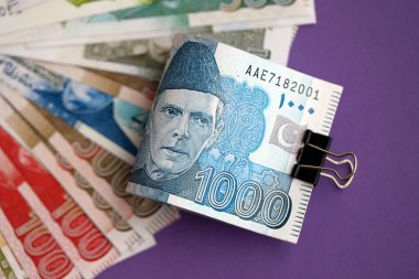Pakistan mor arka planda banknotlar halinde. Pakistan 'ın mevcut para faturaları büyük miktarda masada yatıyor. Pakistan 'da iş ve yatırım kavramı
