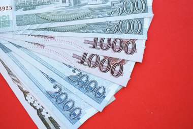 Kuzey Kore büyük miktarlarda para kazandı. Yakın plan kırmızı masada yatıyor. Finans ve bankacılık kavramı