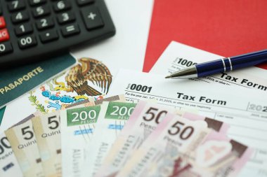 Meksika pezosu para faturaları kalem, hesap makinesi, pasaport ve vergi formlarıyla dolu. Finans ve bankacılık kavramı