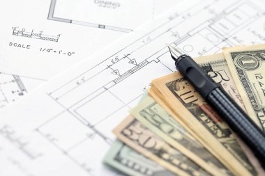 Kalemle birlikte yüklü miktarda Amerikan doları banknotları ve konut projesinin planları yakın plan. Yatırım ve inşaat projesi kavramı