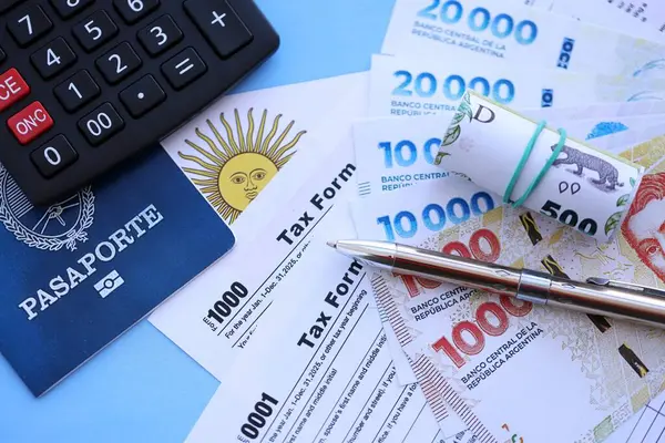 Arjantin Pezosu 'nun para faturaları kalem, hesap makinesi, pasaport ve vergi formlarıyla dolu. Finans ve bankacılık kavramı