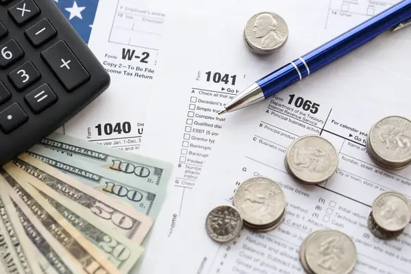 Amerikan Doları. Para banknotları ve vergi formundaki kalem ve hesap makineli paralar boş. Muhasebe ve vergi ödeme dönemi kavramı