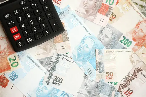 Brezilya banknotları ve hesap makinesi. Mevcut Brezilya gerçek para ve hesap makinesi büyük miktarda masada yatıyor. Brezilya 'da vergilendirme ve para konsepti