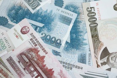 Kuzey Kore büyük miktarlarda para kazandı. Beyaz renkli masada yatıyor. Yakın plan. Finans ve bankacılık kavramı