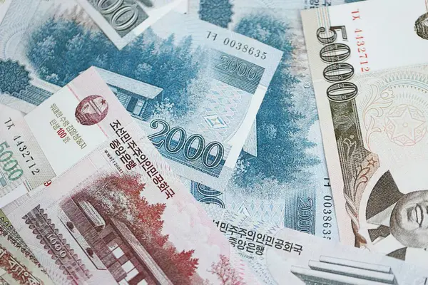 Kuzey Kore büyük miktarlarda para kazandı. Beyaz renkli masada yatıyor. Yakın plan. Finans ve bankacılık kavramı