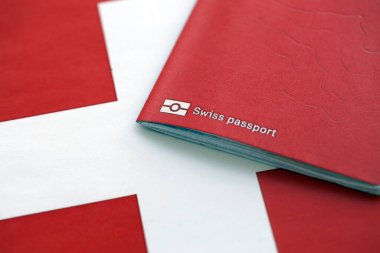 Bayrağın üstünde İsviçre pasaportu. Şimdiki İsviçre bayrağı yakından geçiyor. İsviçre 'de vatandaşlık kavramı