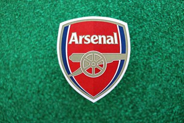 KYIV, UKRAINE - 23 Şubat 2025 Arsenal FC futbol kulübü rozeti zümrüt yeşili simli arka plan pankartıyla uzanır