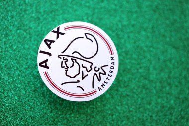 KYIV, UKRAINE - 23 Şubat 2025 AFC Ajax futbol kulübü rozeti zümrüt yeşili simli arka plan afişinde yatıyor