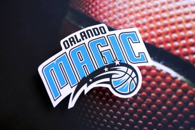 KYIV, UKRAINE - 23 Şubat 2025 Orlando Magic basketbol takımı rozeti basketbol topu arka plan pankartıyla yatıyor