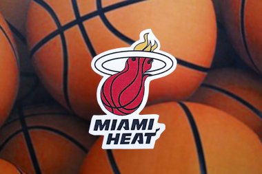KYIV, UKRAINE - 23 Şubat 2025 Miami Heat basketbol takımı rozeti basketbol topu arka plan afişinde yatıyor