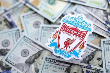 KYIV, UKRAINE - 23 Şubat 2025 Liverpool UK FC futbol kulübü rozeti büyük miktarlarda Amerikan dolarının üzerinde yer almaktadır.