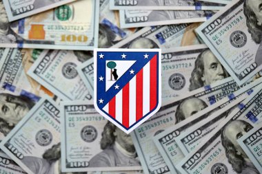 KYIV, UKRAINE - 23 Şubat 2025 Atletico de Madrid futbol kulübü rozeti yüzlük banknotların üzerinde yatıyor