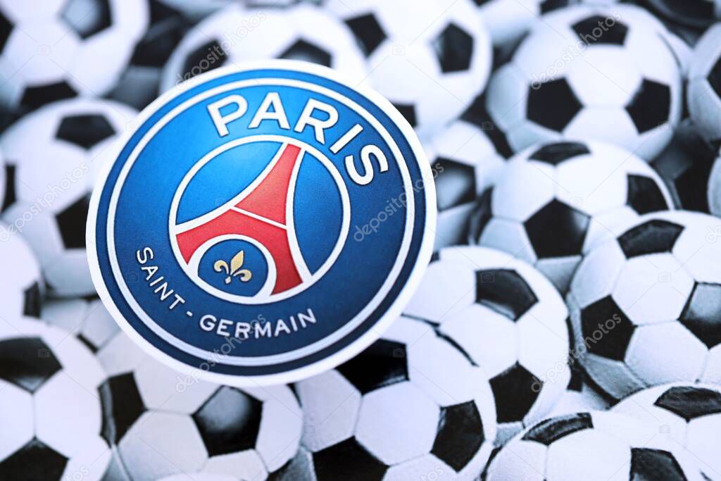KYIV, UKRAINE - FEBRUARY 23, 2025 Paris Saint Germain FC football club badge lies on soccer balls background banner