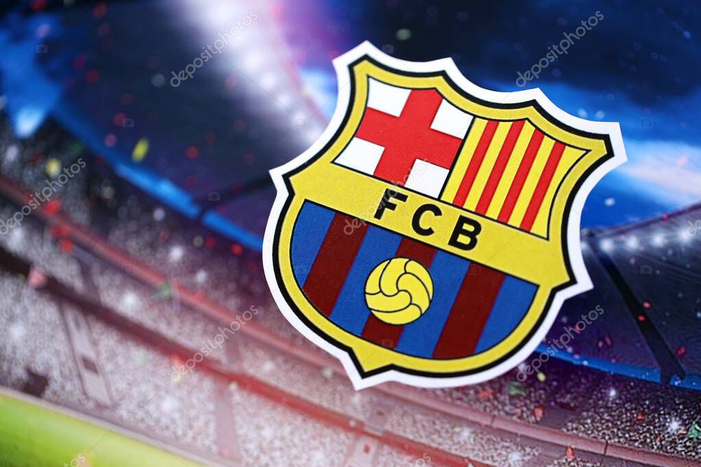 KYIV, UKRAINE - FEBRUARY 23, 2025 FC Barcelona football club badge lies on soccer stadium background banner
