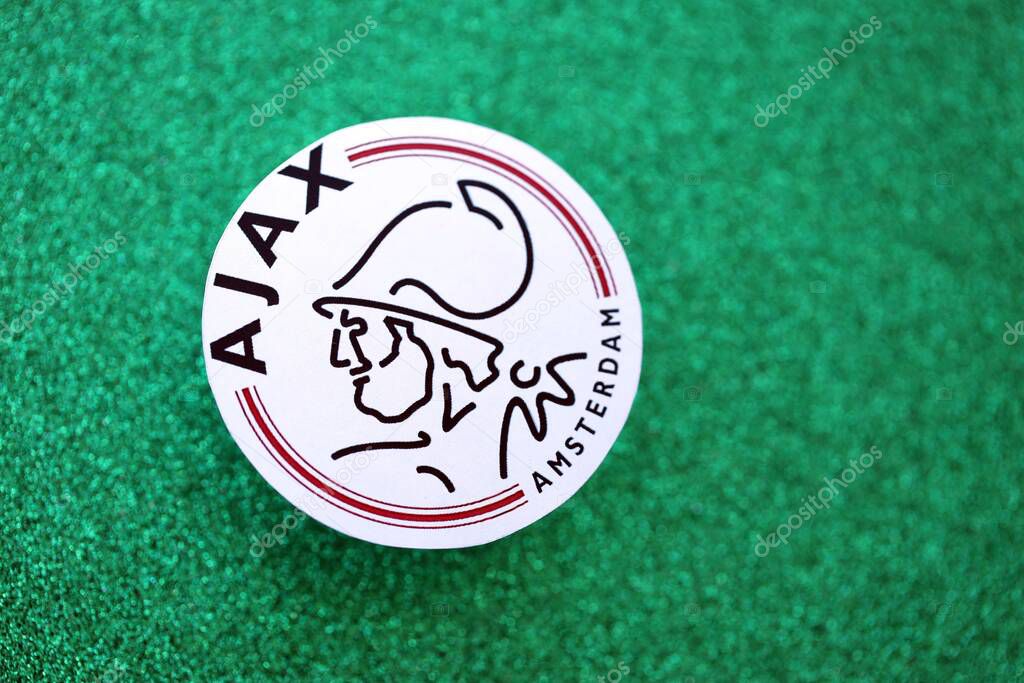 KYIV, UKRAINE - FEBRUARY 23, 2025 AFC Ajax football club badge lies on emerald green glitter background banner