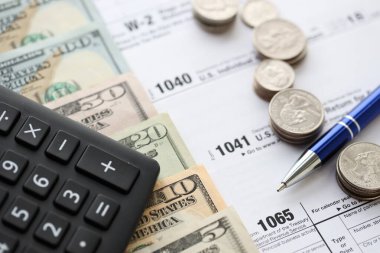 Amerikan Doları. Para banknotları ve vergi formundaki kalem ve hesap makineli paralar boş. Muhasebe ve vergi ödeme dönemi kavramı