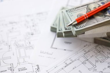 Kalemle birlikte yüklü miktarda Amerikan doları banknotları ve konut projesinin planları yakın plan. Yatırım ve inşaat projesi kavramı