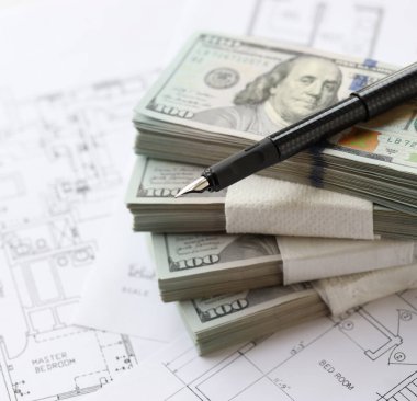 Kalemle birlikte yüklü miktarda Amerikan doları banknotları ve konut projesinin planları yakın plan. Yatırım ve inşaat projesi kavramı