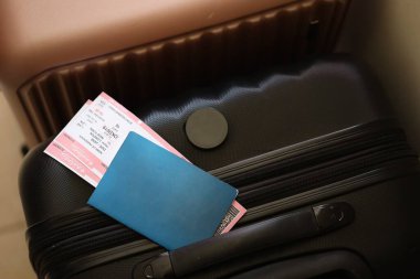 Biletli boş pasaport havaalanı bekleme salonundaki turistik bavulun üzerinde duruyor. Dünya çapında seyahat ve uluslararası turizm kavramı