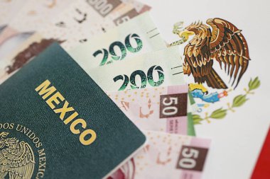 Meksika pezosu büyük miktarda para ve pasaport Meksika bayrağına yakın duruyor. Finans ve bankacılık kavramı