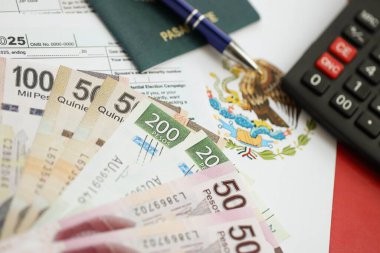 Meksika pezosu para faturaları kalem, hesap makinesi, pasaport ve vergi formlarıyla dolu. Finans ve bankacılık kavramı