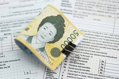 Güney Kore büyük miktarlarda para kazandı. Masada vergi formları var. Muhasebe ve vergilendirme kavramı