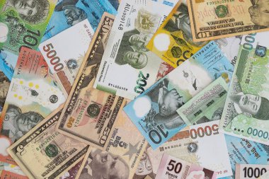 Farklı para birimlerinden ve ülkelerden yüklü miktarda para. Uluslararası nakitin çeşitli arka planında büyük bir yığın var.