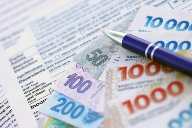 Arjantin pezosu. Büyük miktarda para. Masada, kalem ve vergi formları var.