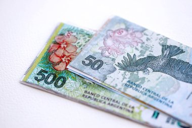 Arjantin pezosu büyük miktarlarda para beyaz masada yakın planda yatıyor. Finans ve bankacılık kavramı