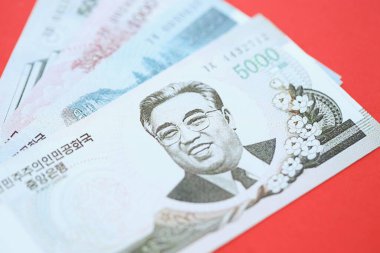 Kuzey Kore büyük miktarlarda para kazandı. Yakın plan kırmızı masada yatıyor. Finans ve bankacılık kavramı